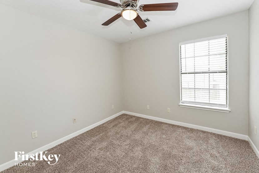 a bedroom with carpet and a ceiling fan