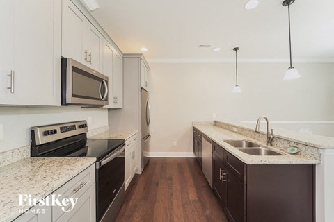 A kitchen with a stove top oven and microwave built into the cabinetry.