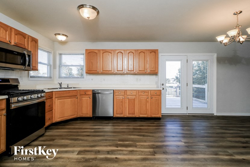 a kitchen with wooden cabinets and a door to a balcony