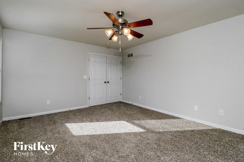 the master bedroom has a ceiling fan and carpeted flooring