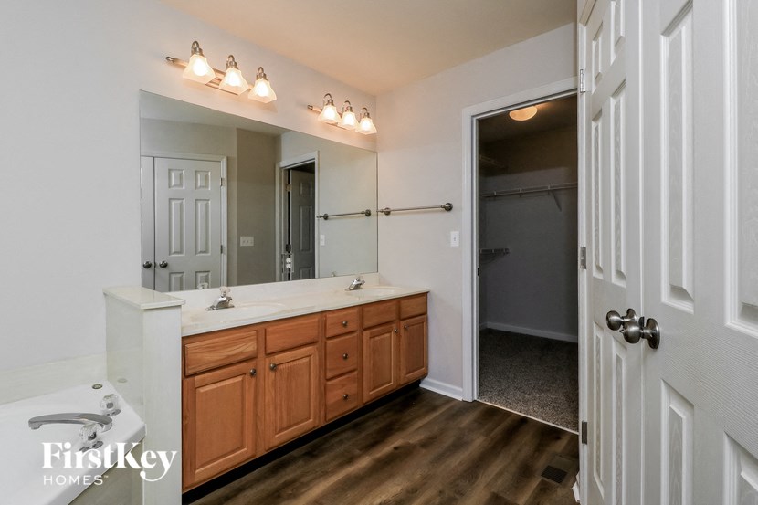 the master bathroom has a large vanity and a large mirror
