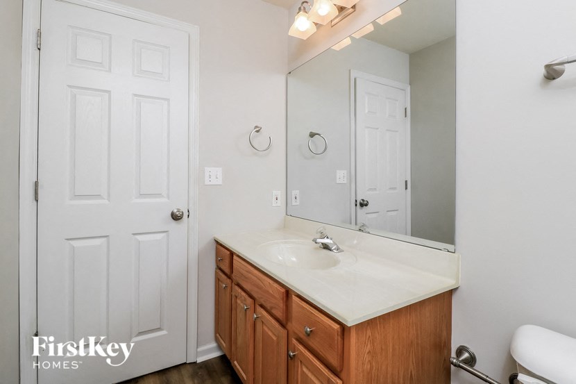 a bathroom with a sink and a mirror and a door