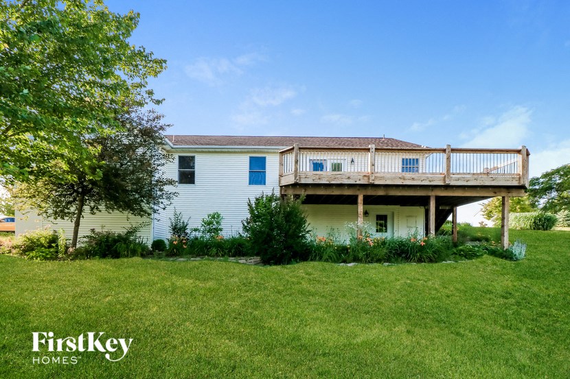 the back of a house with a deck and a yard