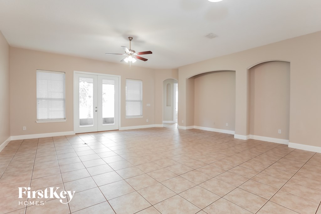 A spacious room with a fan and tile flooring.