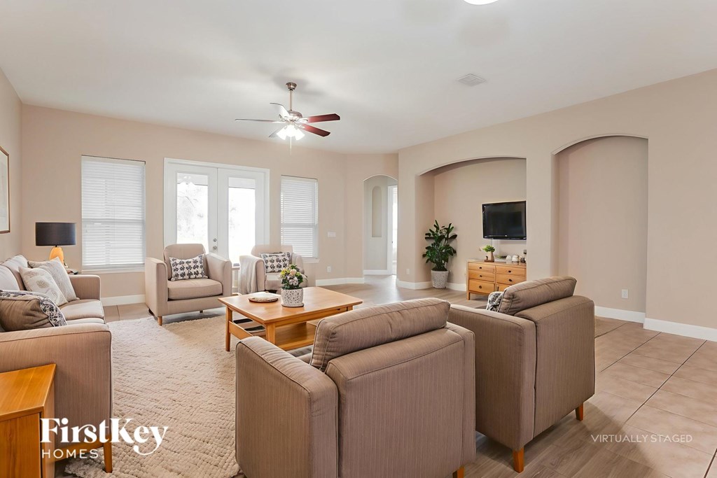 A living room with a beige carpet and furniture.