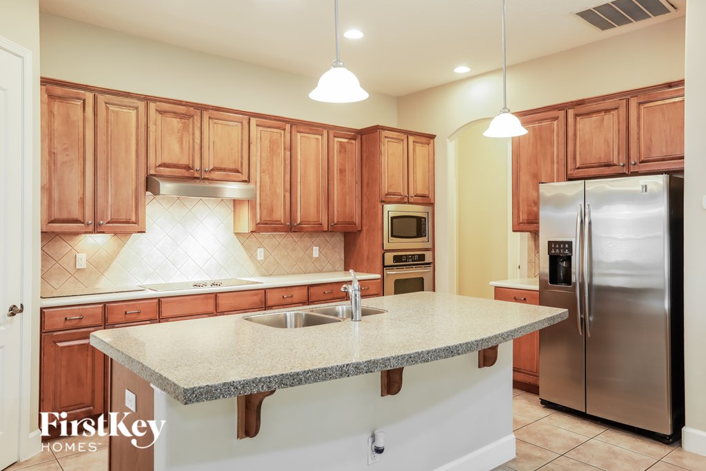 A kitchen with wooden cabinets and a granite countertop.