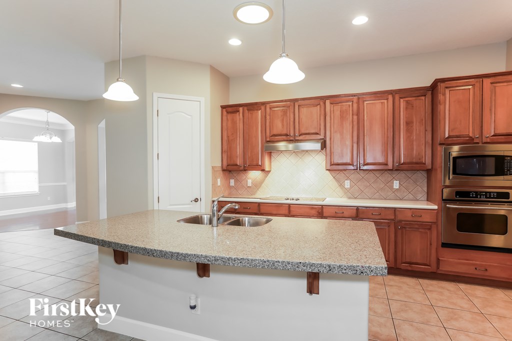 A kitchen with wooden cabinets and a granite countertop.