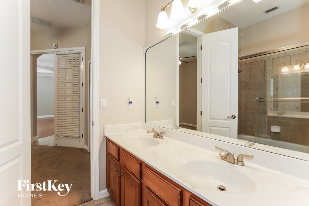 A bathroom with a double sink and a large mirror.