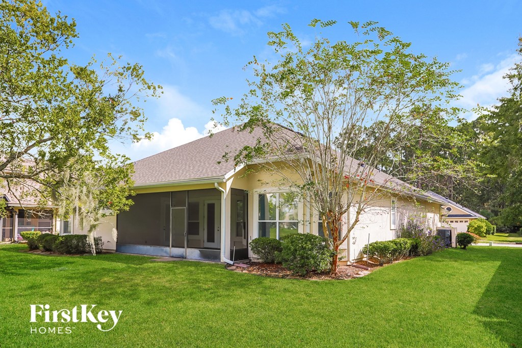 A house with a lawn and trees in front of it.