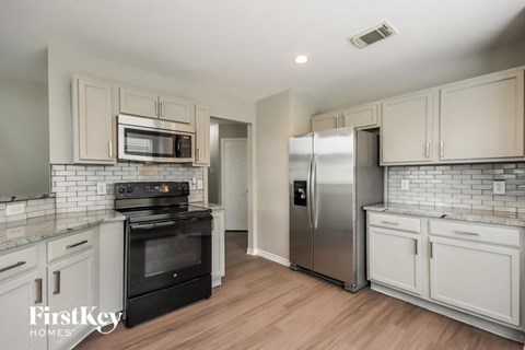 a kitchen with stainless steel appliances and white cabinets