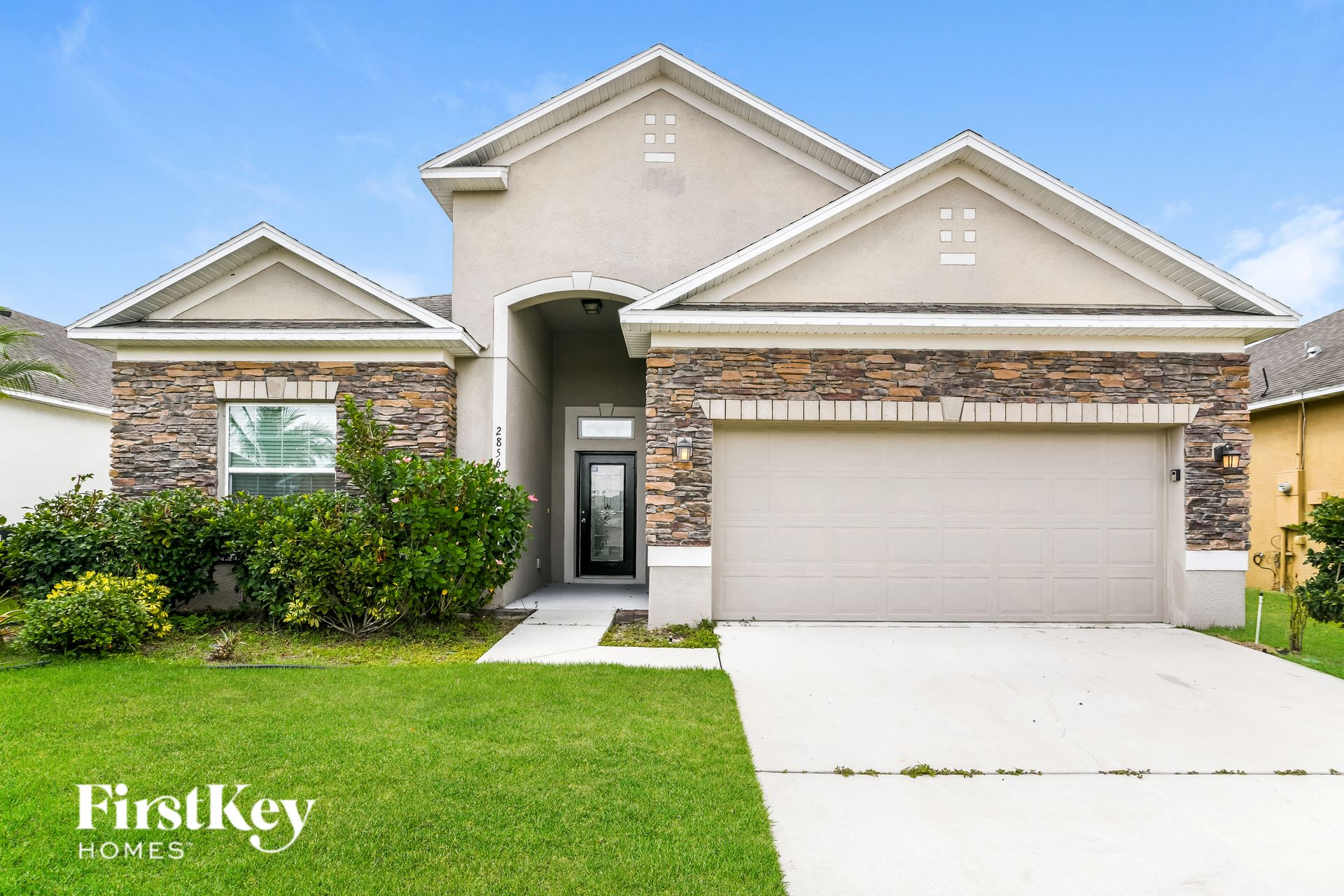 a house with a garage door and a lawn