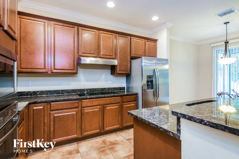 a kitchen with wooden cabinets and a stainless steel refrigerator
