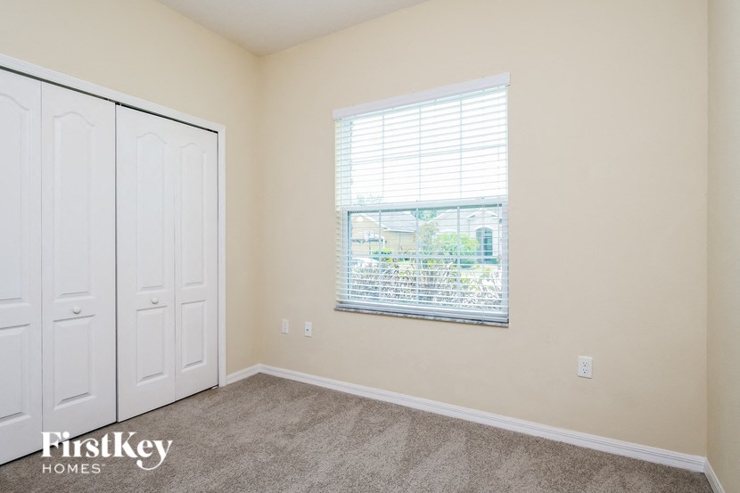a bedroom with a window and a closet