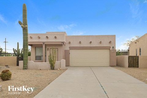 a house with a driveway and a cactus in front of it