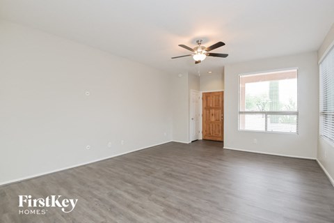 a living room with a ceiling fan and a large window