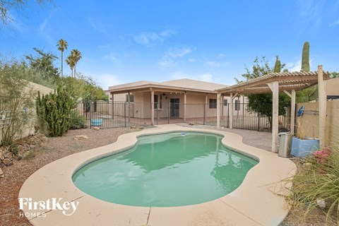 a swimming pool in front of a house with a pool