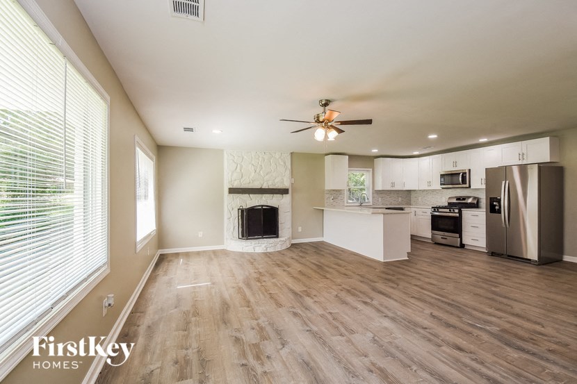 a kitchen and living room with wood flooring and a ceiling fan
