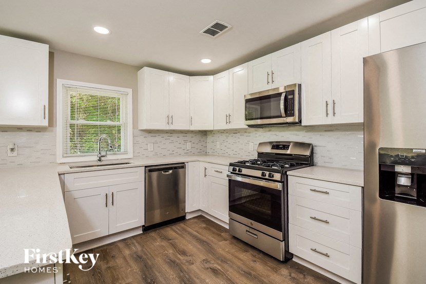 a kitchen with white cabinets and stainless steel appliances