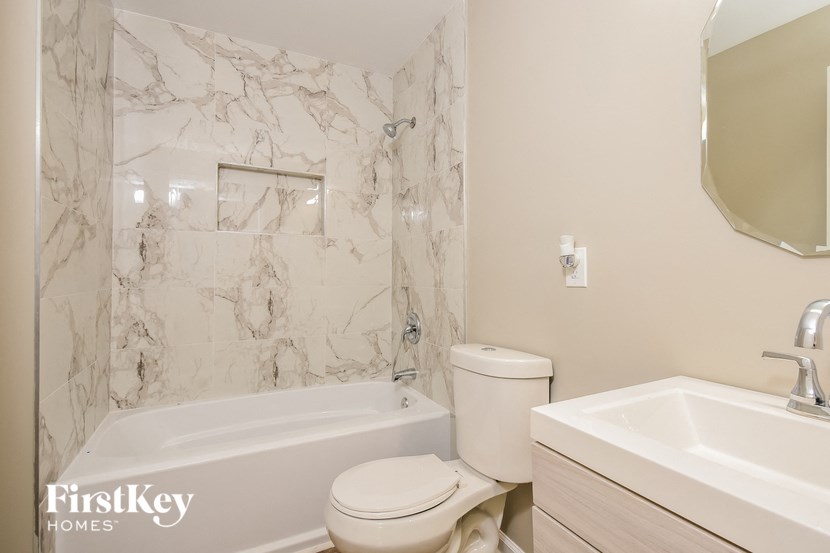 a bathroom with a toilet and a tub and a sink
