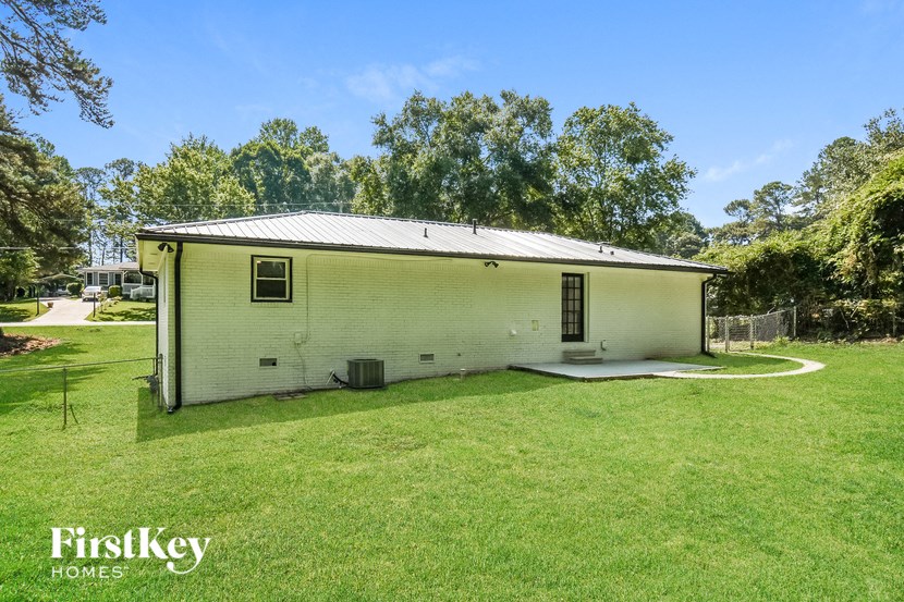 a small white house with a yard and trees