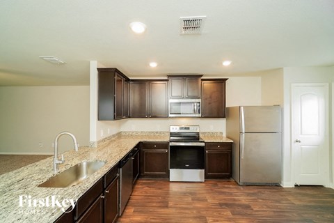 A kitchen with dark wood cabinets and stainless steel appliances.