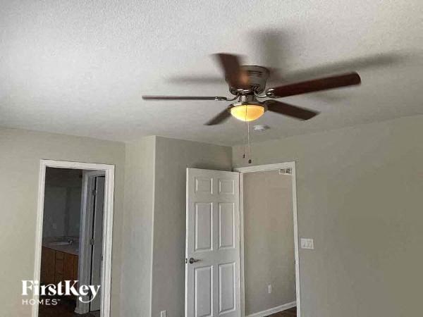 a ceiling fan with a light on it in a room