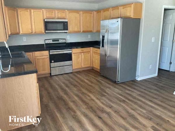 a kitchen with wooden floors and a stainless steel refrigerator