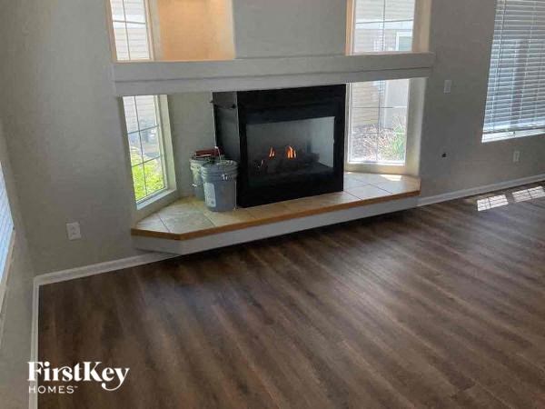 a living room with a fireplace and a wooden floor