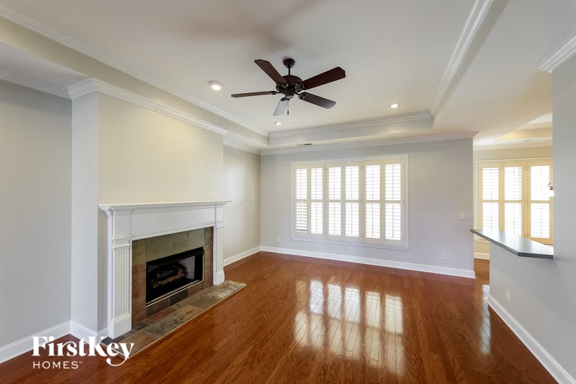 A spacious room with a fireplace and wooden floors.