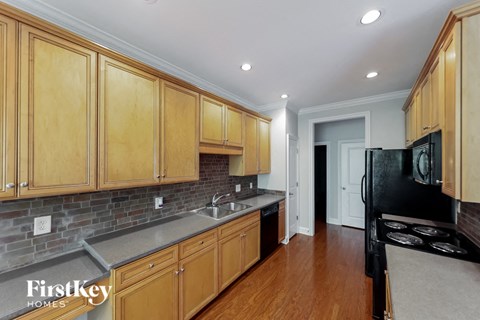 A kitchen with wooden cabinets and a black stove top oven.