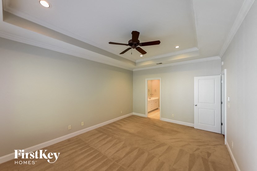 A room with a ceiling fan and light fixture.