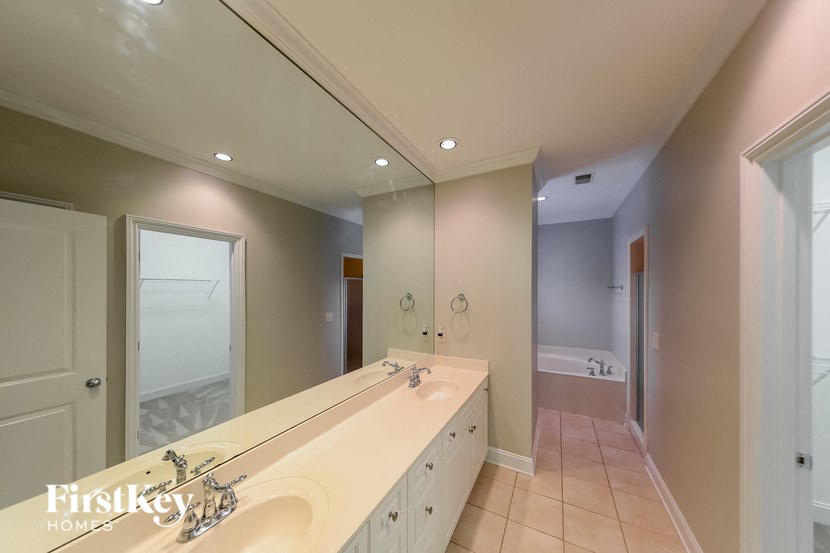 A bathroom with a large mirror and a sink.