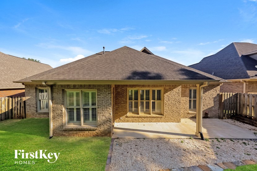 A house with a brown roof and a porch is for sale.