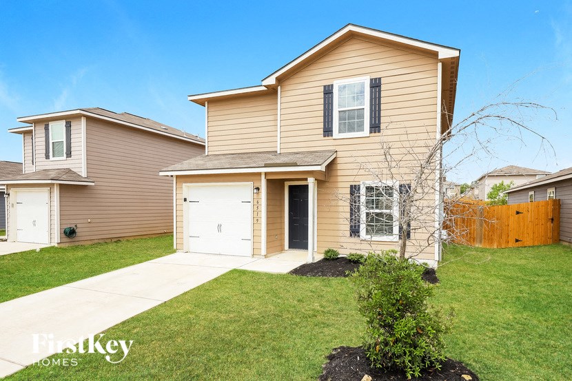 a tan house with a white garage door