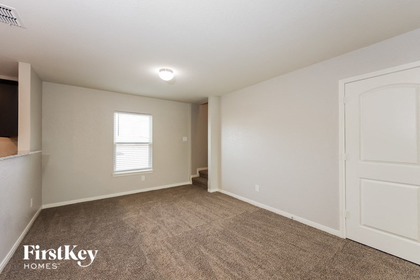 a living room with a carpeted floor and a white door