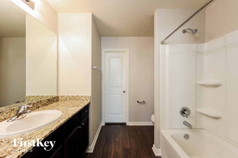a bathroom with a tub and a sink and a mirror