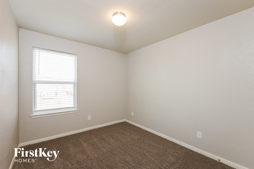the bedroom of a home with a carpeted floor and a window