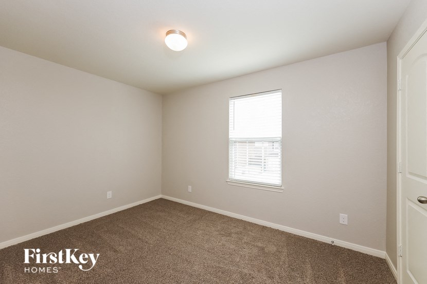 the living room of a home with a window and carpet