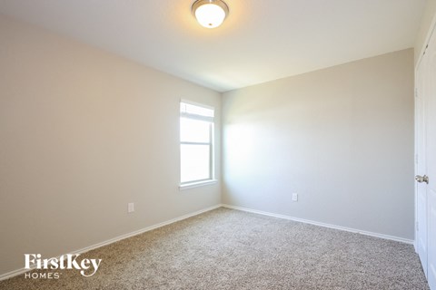 a bedroom with a window and a carpeted floor