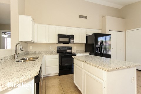 a kitchen with granite counter tops and black appliances