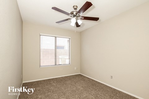 a bedroom with a ceiling fan and a window