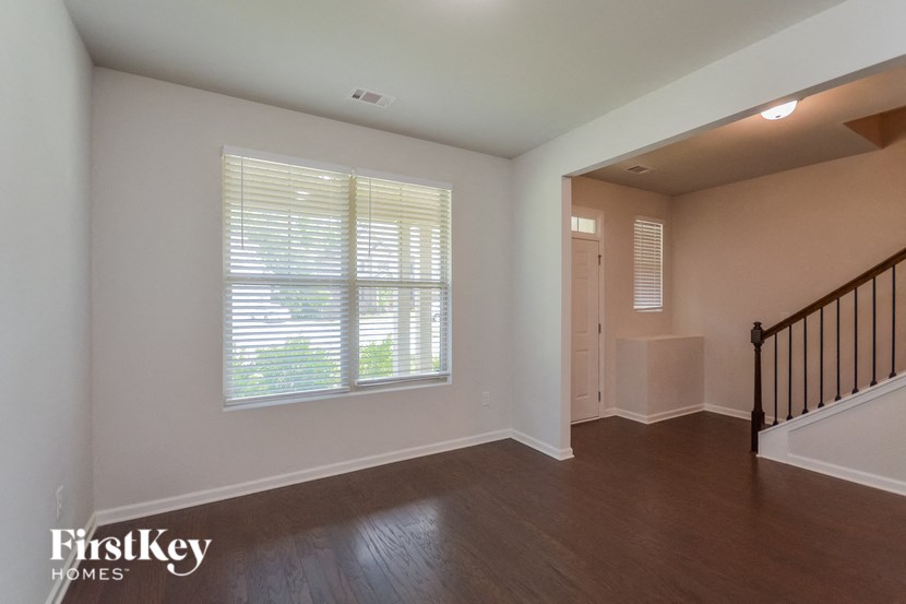 a living room with a staircase and a large window
