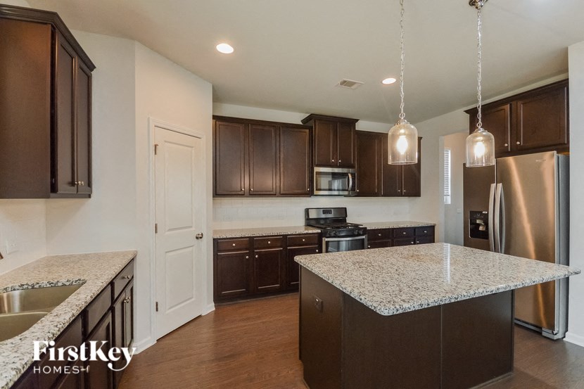 a kitchen with granite counter tops and wooden cabinets