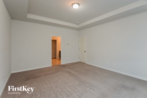 a spacious living room with carpet and white walls