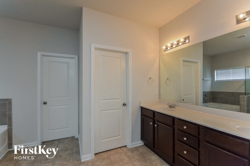 a bathroom with a sink and a mirror and two doors
