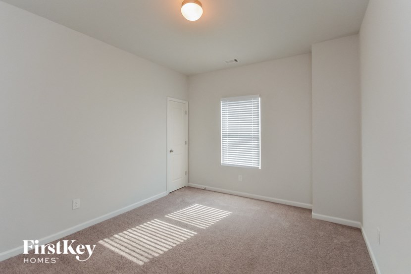 a spacious living room with white walls and a white door