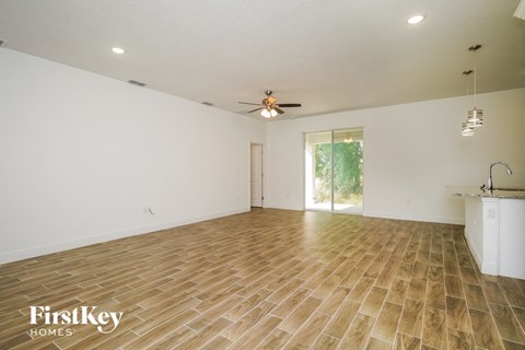 the living room with wood floors and a ceiling fan