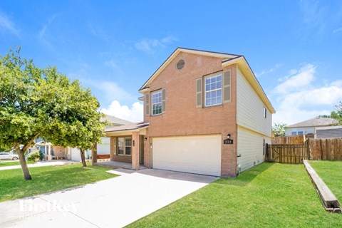 a brick house with a white garage door and a lawn