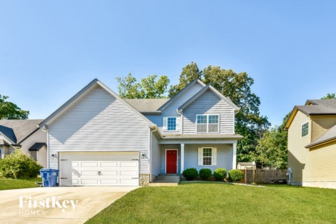 a white house with a red door and a lawn