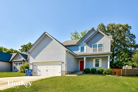 a blue house with a white garage door and a green lawn